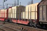 DB SCHENKER Drehgestellflachwagen mit vier Rads�tzen, Stirnw�nden und Rungen, jedoch ohne Seitenw�nde beladen mit Schnittholzbrettern.