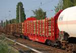 Ein Drehgestellflachwagen mit vier Rads�tzen und Rungen vom Typ Roos 639 der DB mit Rundholz beladen, 02.07.10 in einem gemischten Zugverband Berlin-Karow.