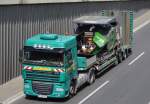 Eine DAF XF 105.460 Zugmaschine der Fa.DOMINIK mit Tiefladebrücke mit einem VOLVO Typ? Asphaltfertiger der Fa.