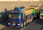 MB ACTROS 3240, ein vierachsiger Baulaster in tollem Blau mit pritschenumrandeter Ladefl�che und PALFINGER Typ PK 54000 Hydraulikgreifarmaufsatz beladen mit Verschalungs-Fertigelementen + H�nger,