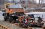 Zweiwege MB Unimog Typ? schiebt und treibt eine Schienenschleifmaschine �ber ein durch Bauarbeiten l�nger nicht genutztes TRAM-Gleis in Berlin, 04.04.13