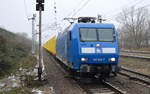 PRESS 145 030-7 (145 085-7) mit einem der typisch gelb leuchtenden Rungenwagenzüge für Stammholz-Transporte (leer) am 25.01.17 Durchfahrt Bf.